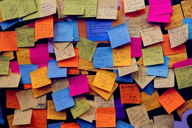 Dozens of colorful post-it notes, with writing ont hem but it's too small to read