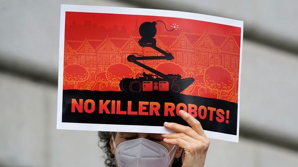 A person holding a sign saying No Killer Robots